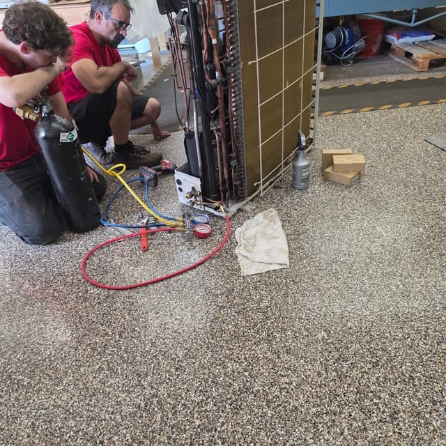 Temp Rise technicians servicing an air handler in the shop